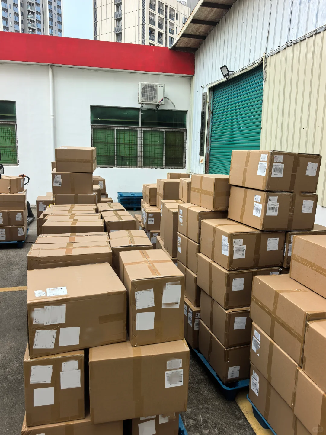 Packed cartons stacked near a warehouse loading area